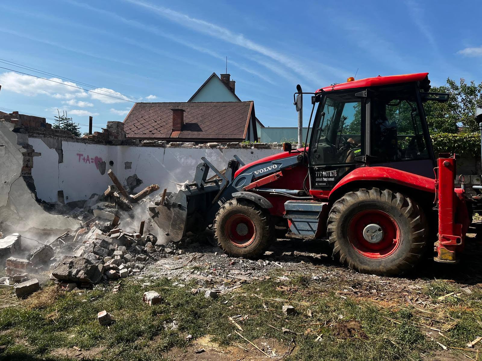 Nakladač bourá obvodovou stěnu objektu