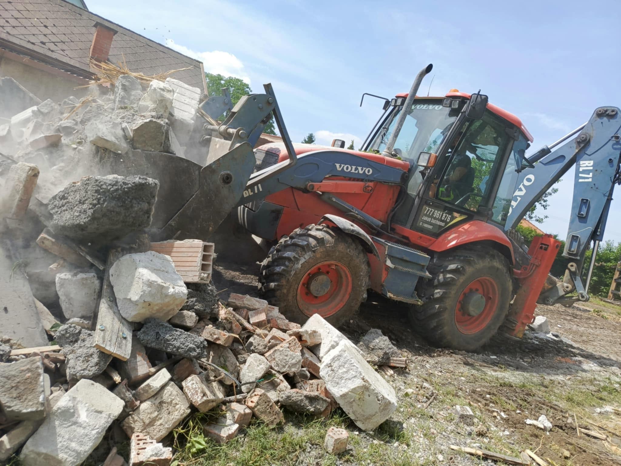 Čelní nakladač při demolici budovy